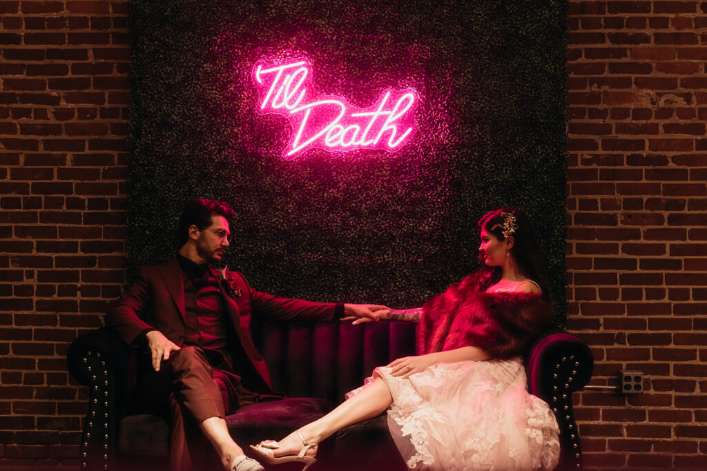Bride and groom in front of neon sign