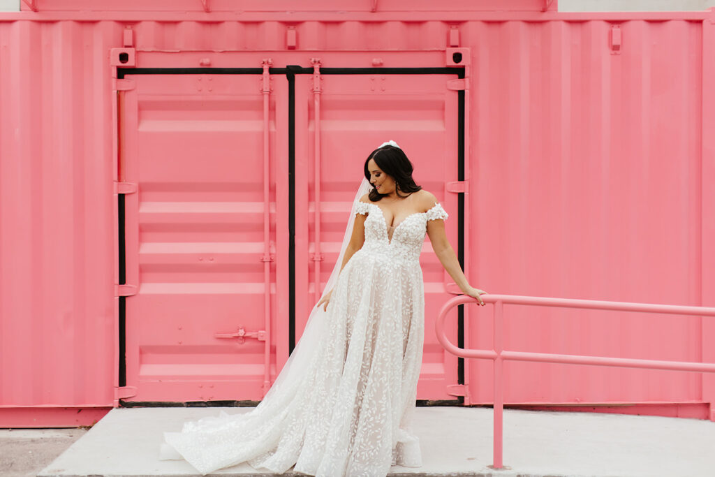 bridal portraits in front of pink wall
