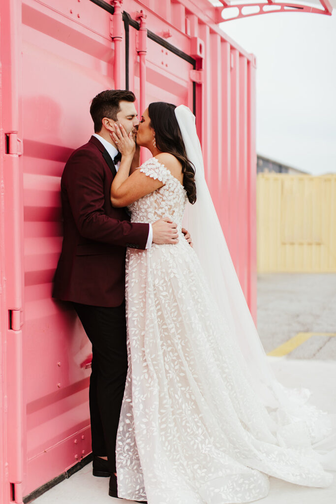bride and groom photos in front of pink wall