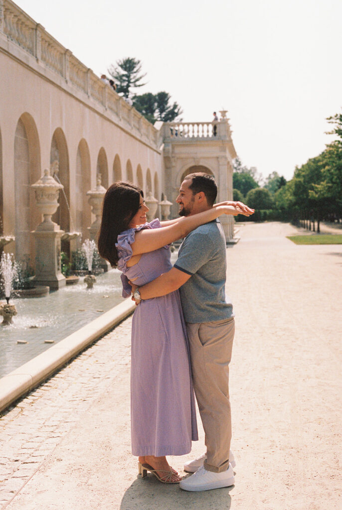 girl wrapping arms around guy for longwood gardens engagement photos