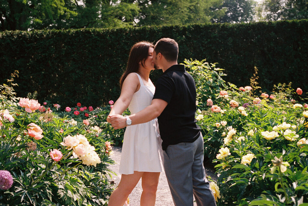 couple kissing in flowers for longwood gardens engagement photos