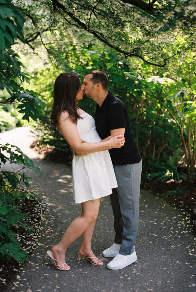 couple kissing in front of trees