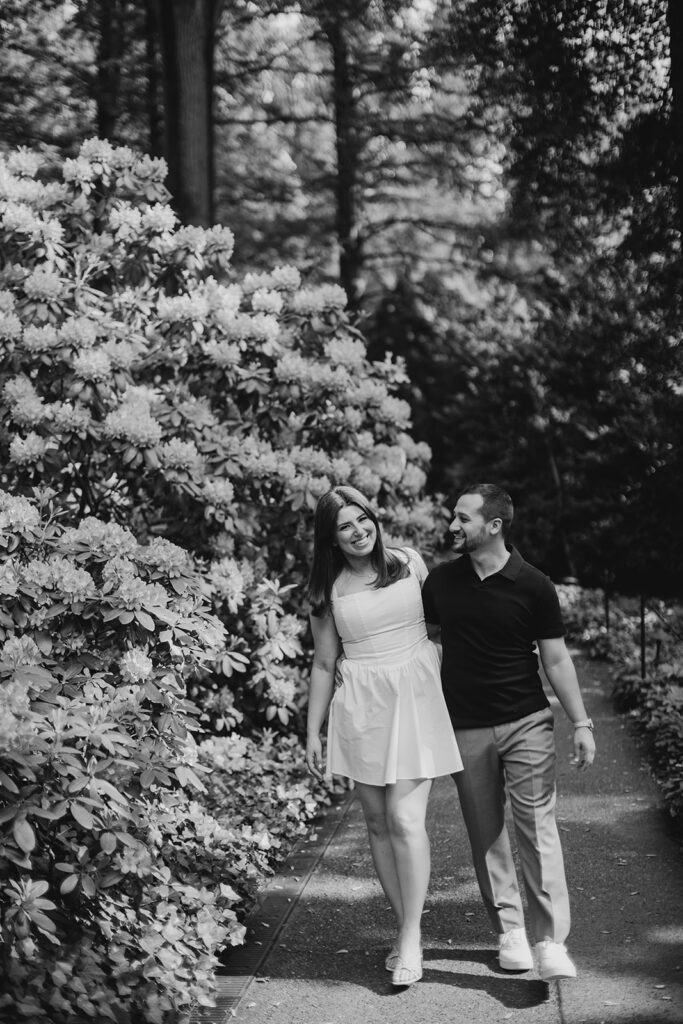 couple holding hands and walking for longwood gardens engagement photos