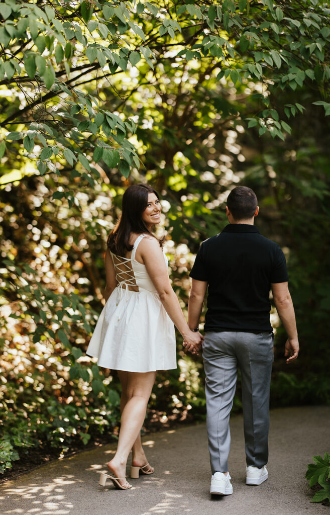 couple holding hands and walking for longwood gardens engagement photos