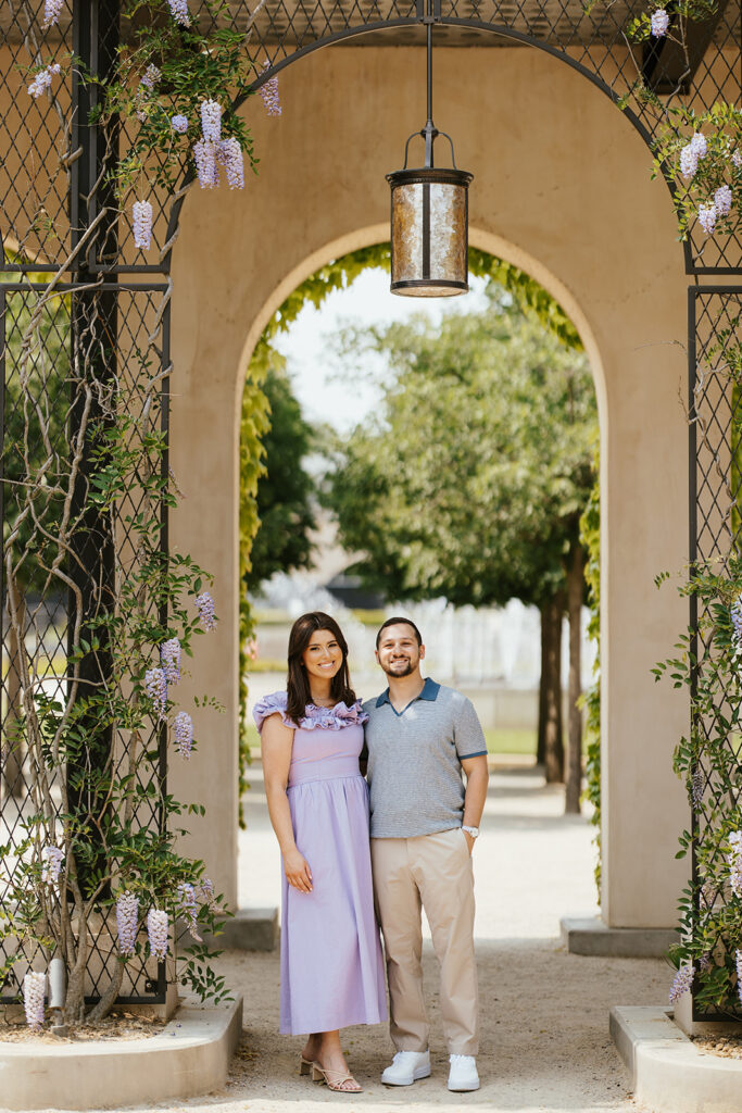 couple standing in front of lavender wall in longwood gardens