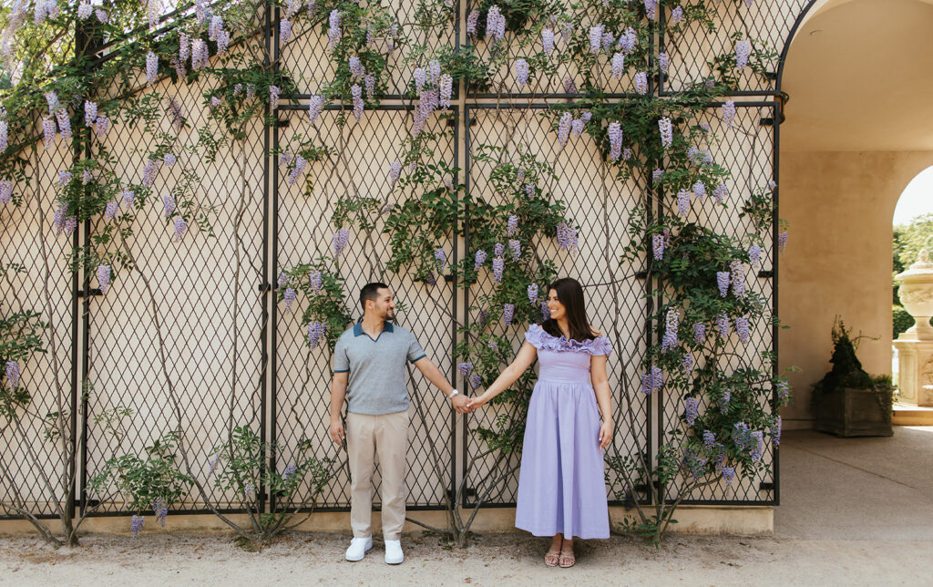 couple holding hands outside of longwood gardens engagement photos