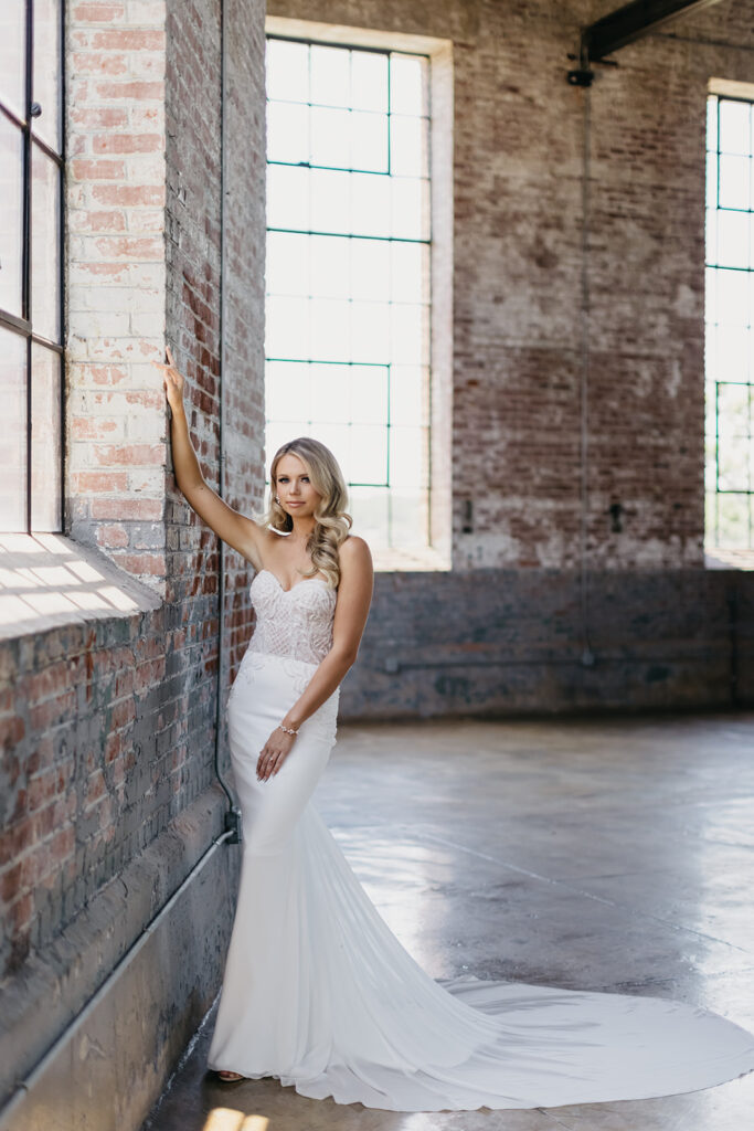 bride leaning up against brick wall