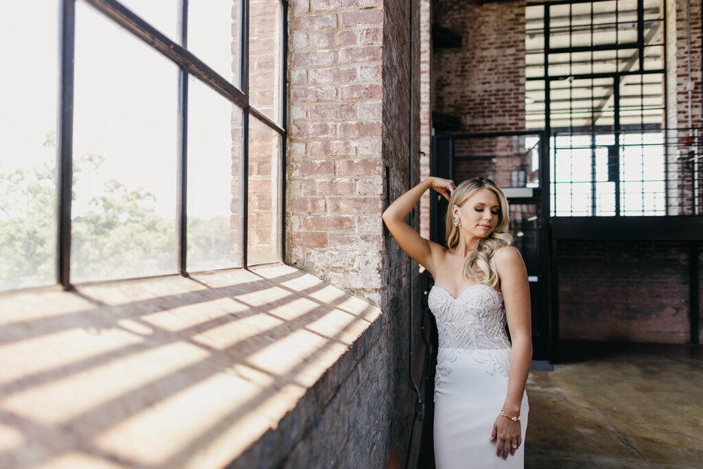 bride leaning up against brick wall for photos
