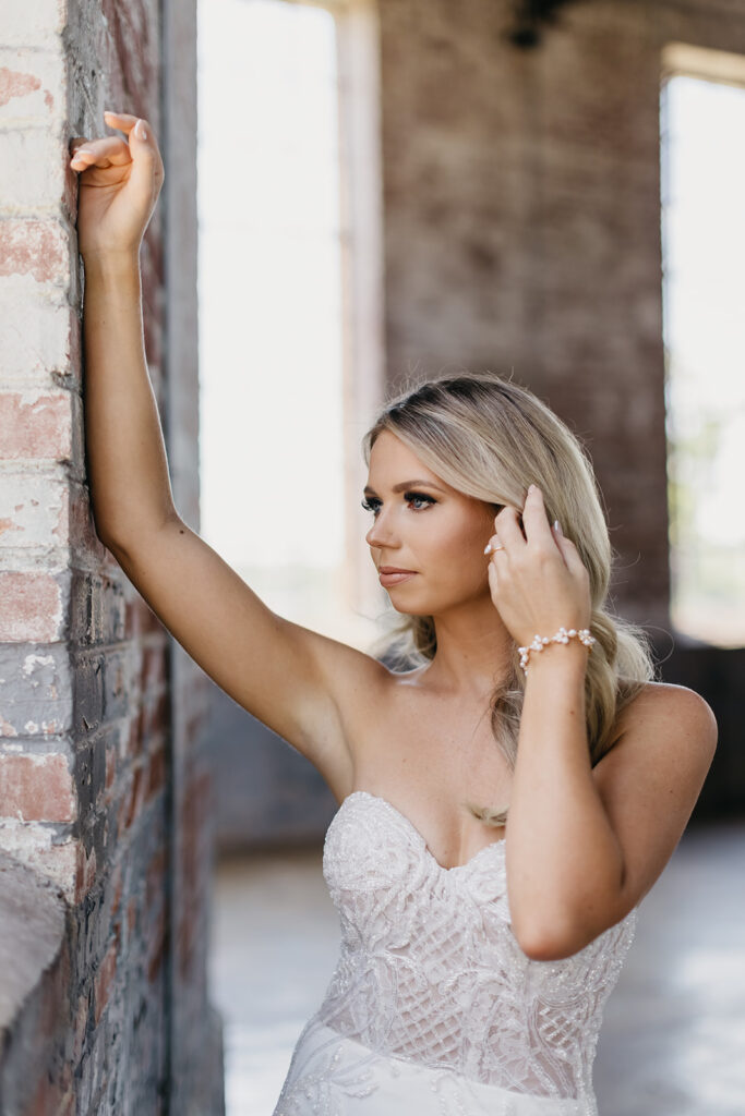 bride leaning up against brick wall