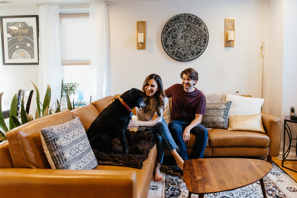 couple laughing with dog for indoor philadelphia engagement pictures