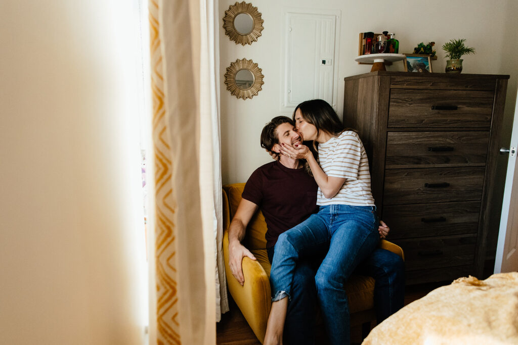 couple kissing in chair at home for philadelphia engagement pictures