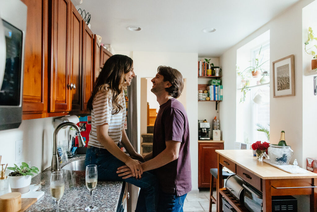 couple sitting on counter in kitchen for philadelphia engagement pictures