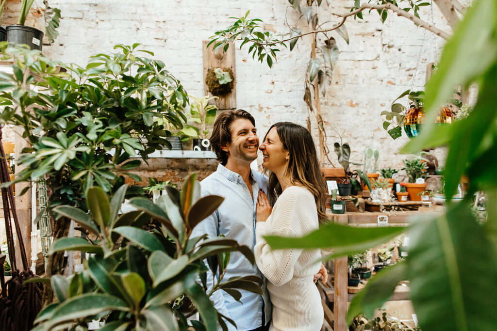 couple smiling and laughing in greenhouse