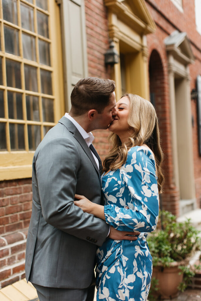 couple kissing in front of brick building