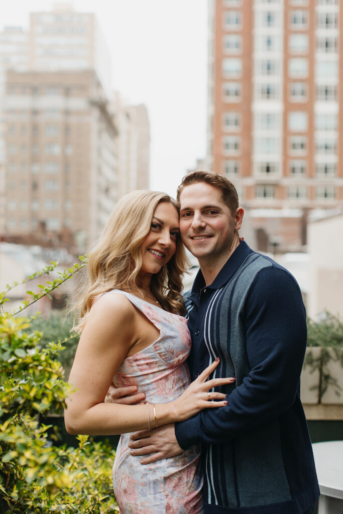 couple smiling in front of city philly engagement photos