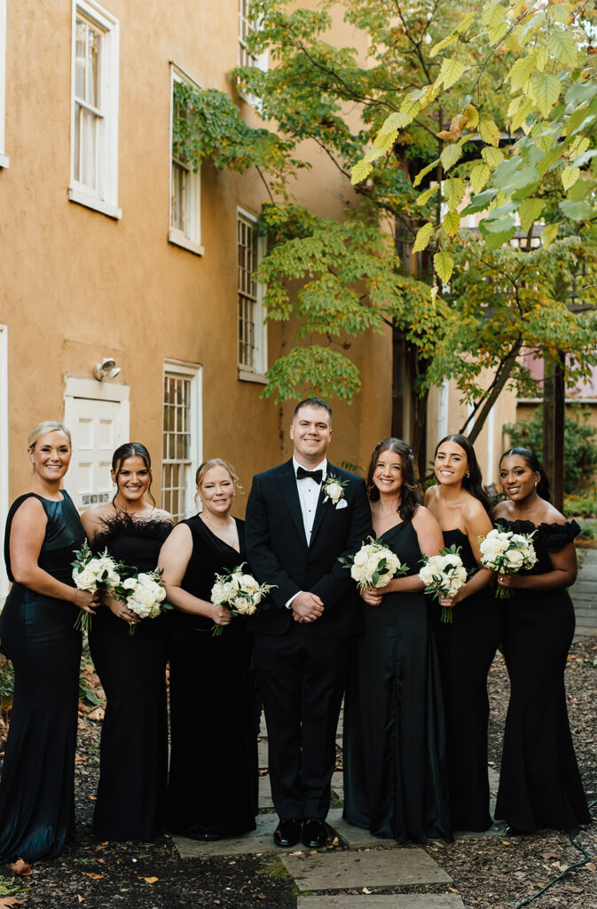 groom with bridesmaids in all black